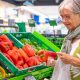 Senior woman selecting fresh vegetables holding a red peppers in