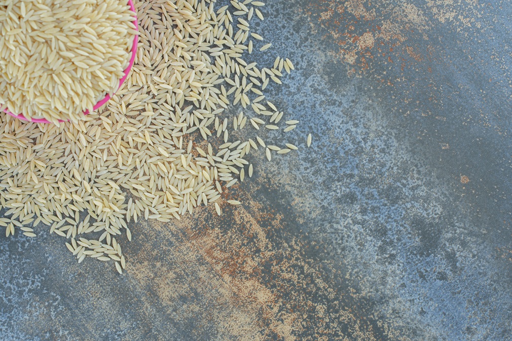 Basmati rice spilled from a bucket, on the marble background