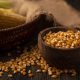 top view of fresh corn kernels on a wooden bowl with kernels isolated on a wooden background